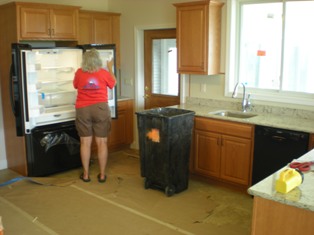 Interior shot of Donna examining her new fridge in the mostly complete kitchen