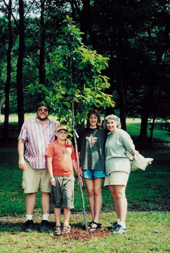 The Rosoce family gather around the young oak after planting it.