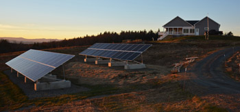 Photo of two sets of solar arrays with the house in the background