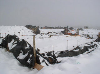 Foundation covered in tarps and snow