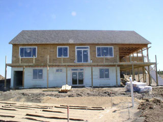 Shingles are on the roof, further progress on the porch, still have an uncovered septic field.